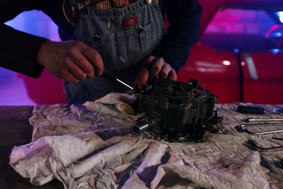A mechanic fixing a vintage car part in a dimly lit garage with neon lights and tools around.